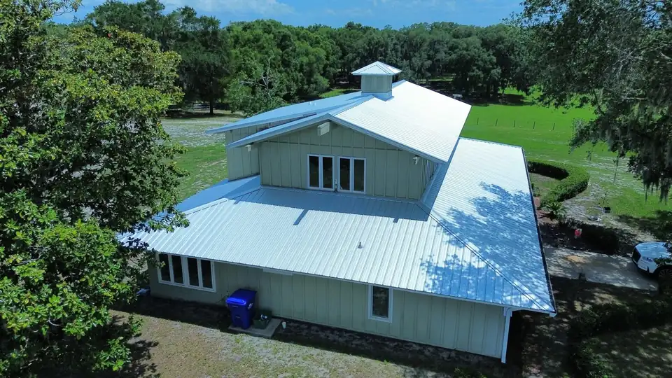 Aerial of a house with a cupola and silver metal roof