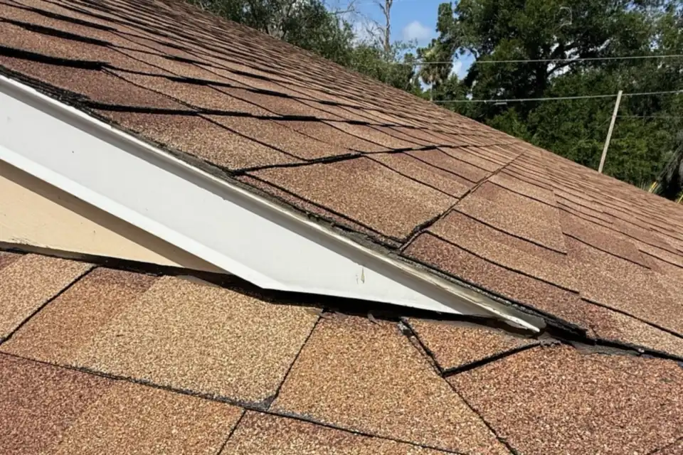Shingle courses meeting the drip edge and gutter at a roof rake