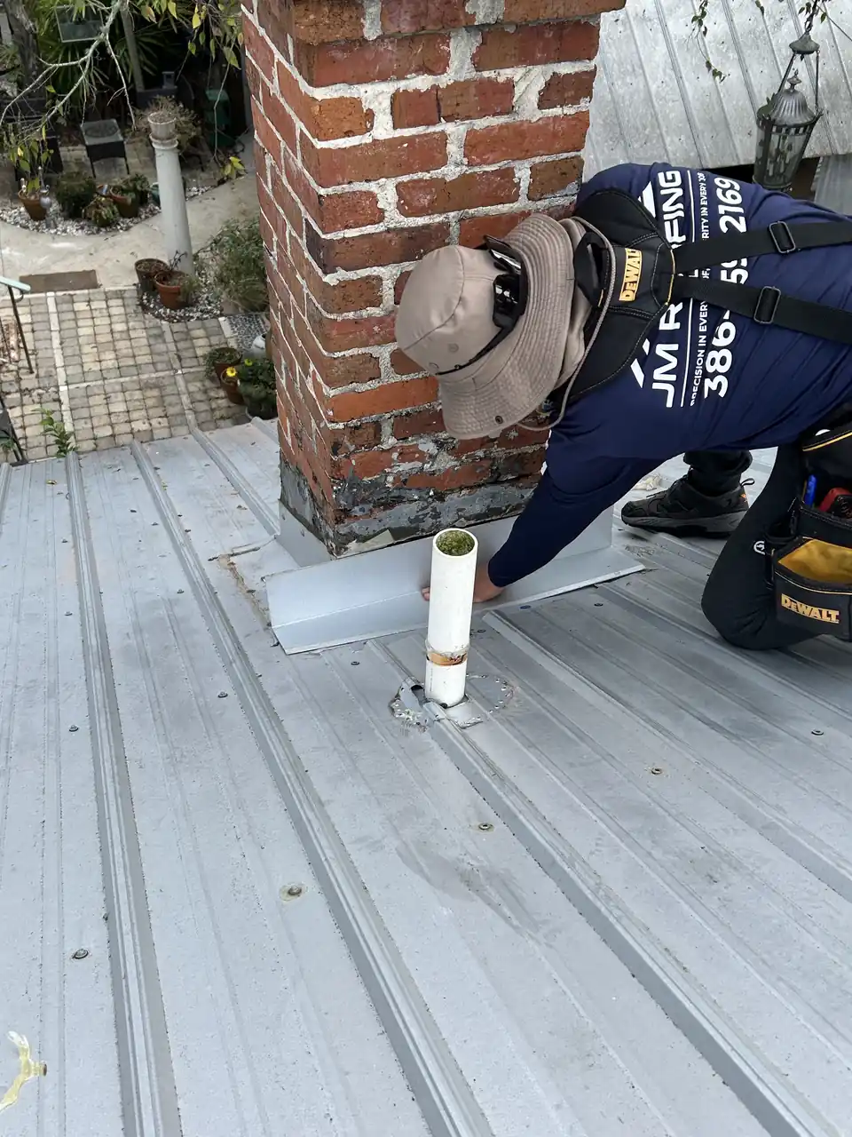 Roofer sealing flashing by a chimney